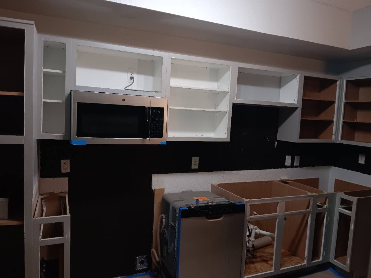 Apartment kitchen during cabinet and countertop installation work.