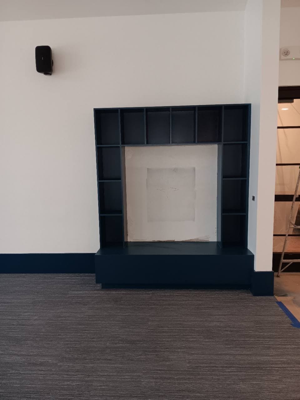 Finished dark built-in feature wall in a completed common area.