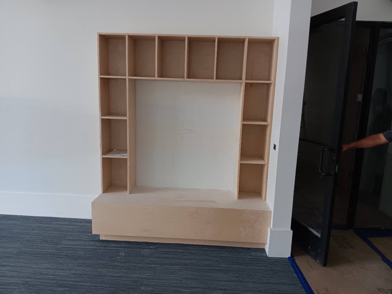 Unfinished raw-wood built-in frame before common-area finish work.