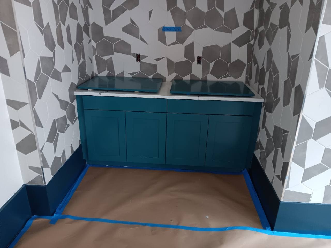 Finished geometric feature wall and lower cabinet in a completed amenity area.